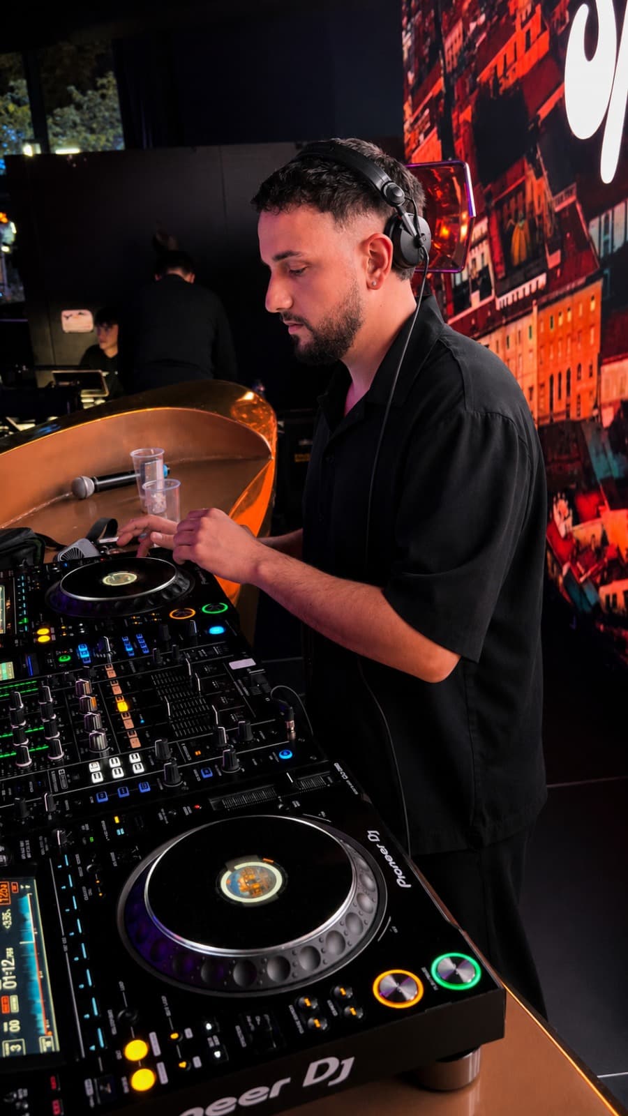 Luca Paone in cuffia ai CDJ Pioneer in un club